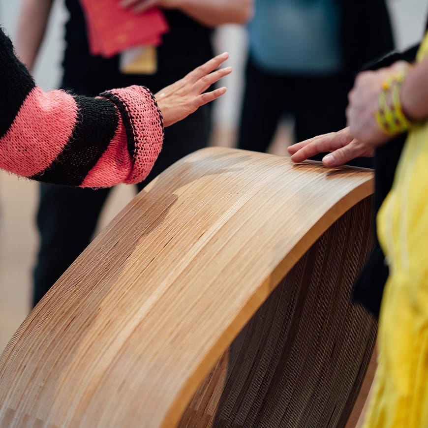 Close up of wooden sculpture with hands touching it