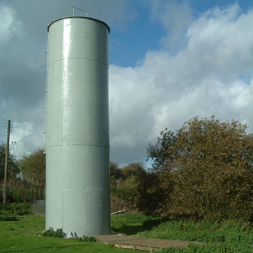 Tower structure surrounded by grass and trees